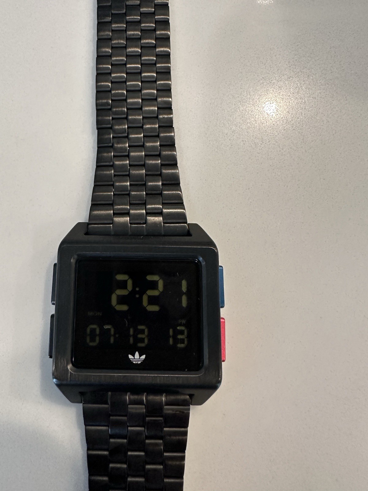 Adidas Archive M1 watch with a matte black finish and a square digital display