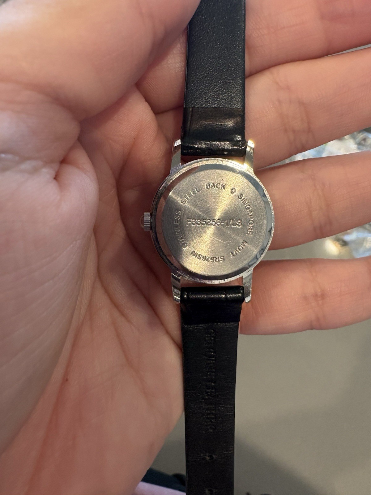 Avon watch featuring a genuine diamond accent on a black leather strap.
