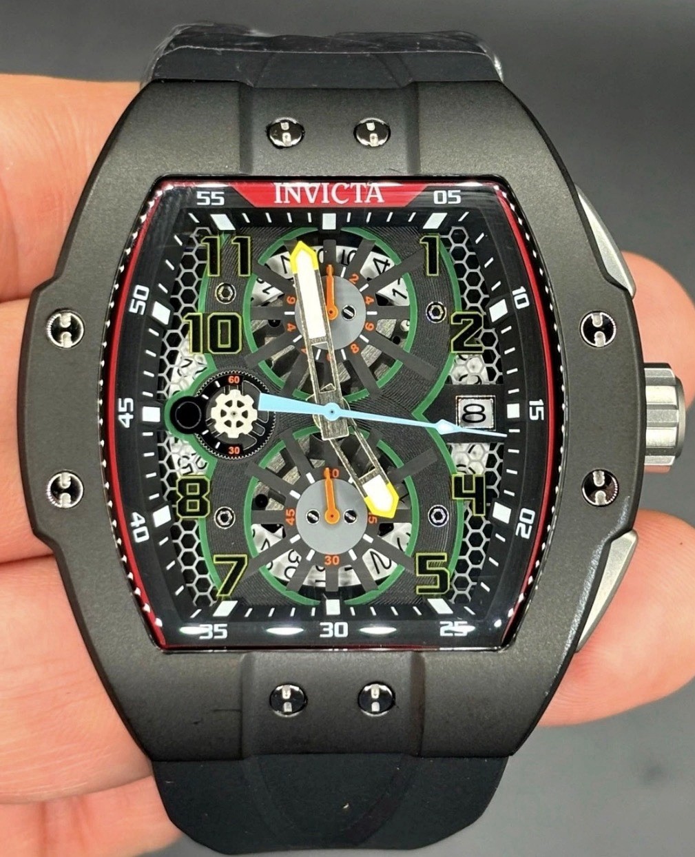 The Invicta 48027 men’s wristwatch features a striking black bezel and case