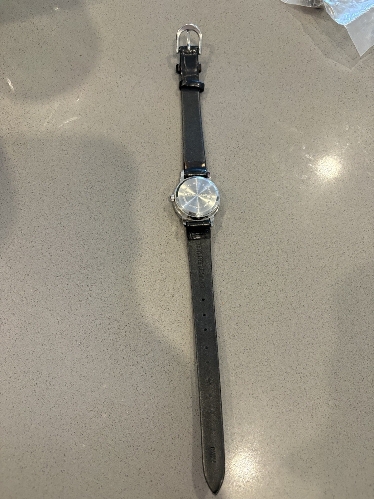Avon watch featuring a genuine diamond accent on a black leather strap.