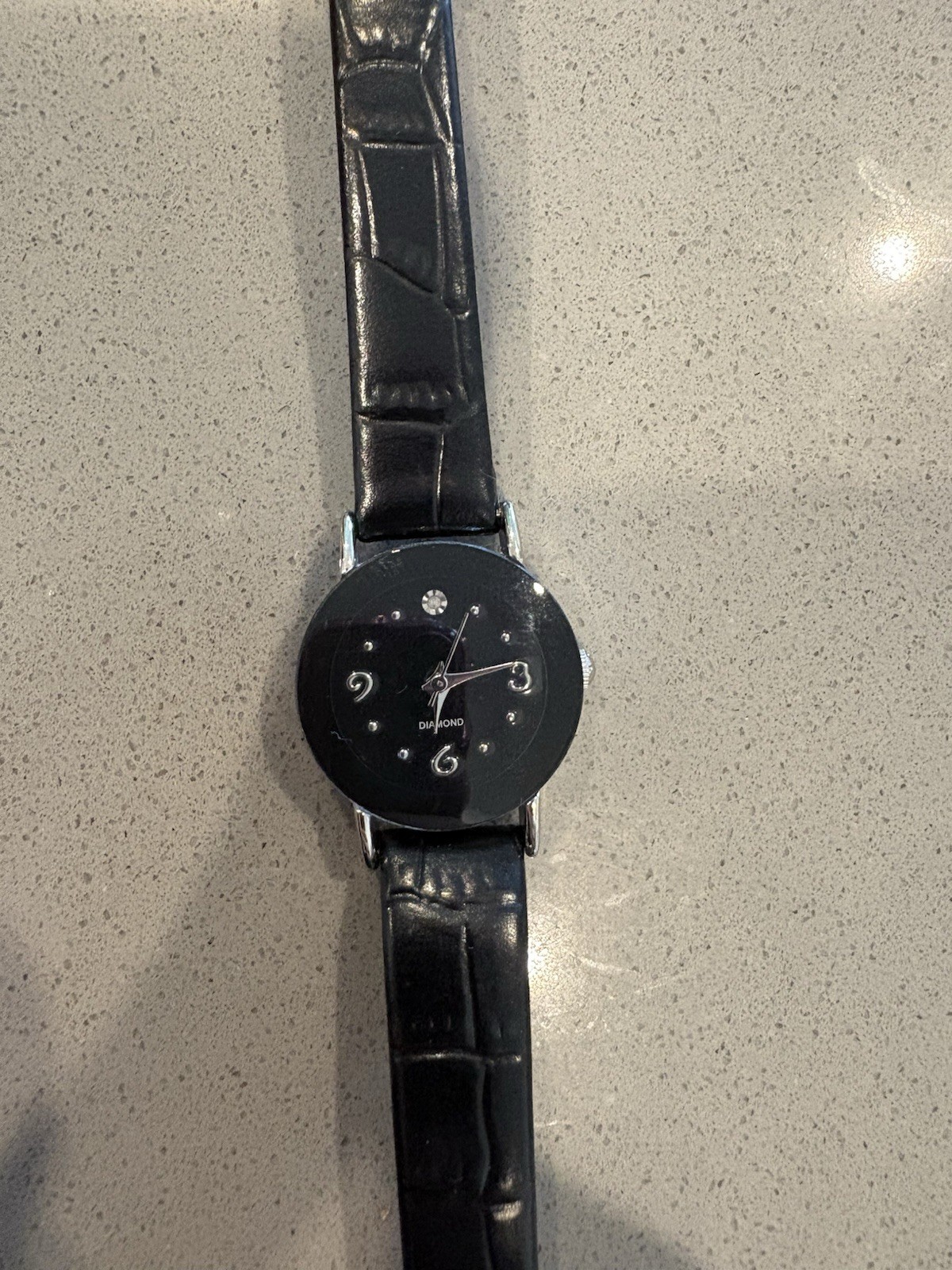Avon watch featuring a genuine diamond accent on a black leather strap.