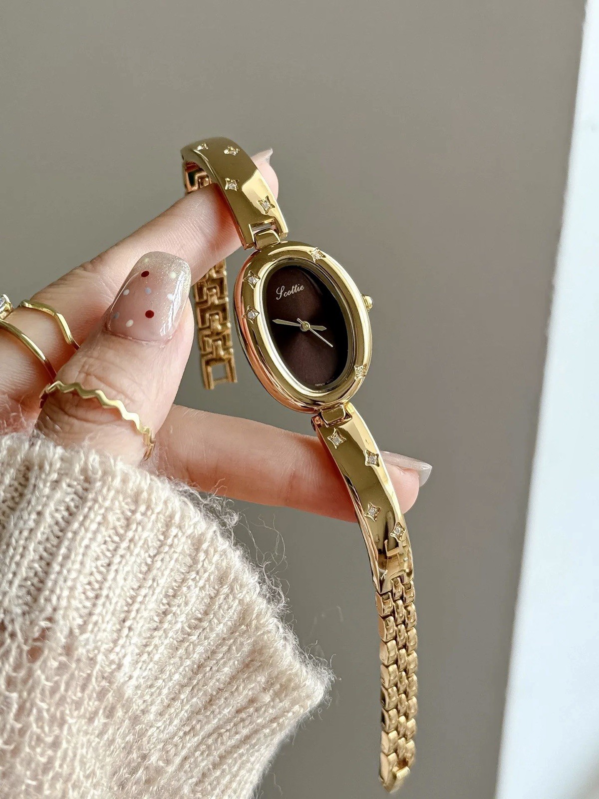 Elegant Gold Oval Ladies Luxury Watch with Dark Brown Maroon Dial & Star Accents