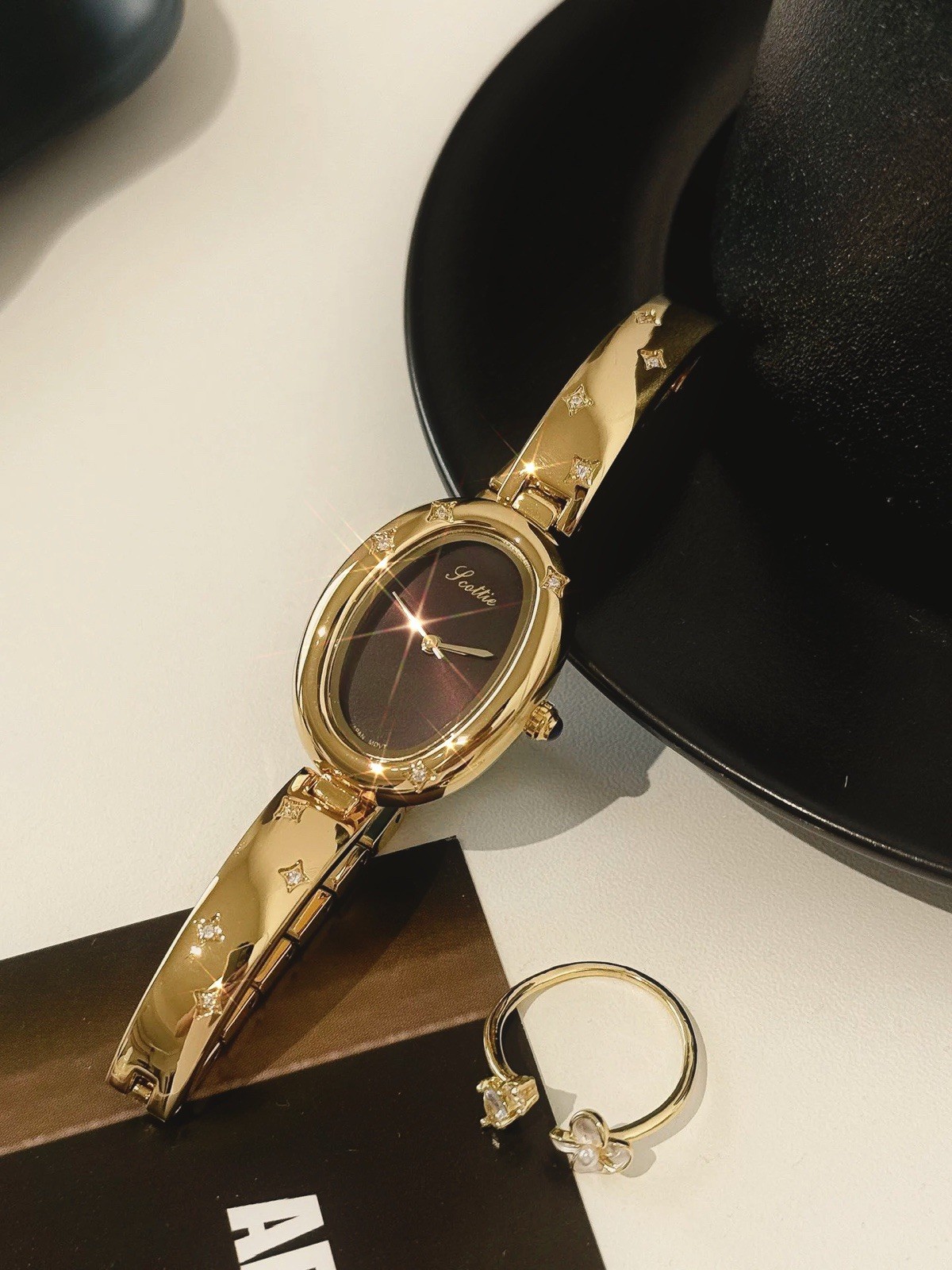 Elegant Gold Oval Ladies Luxury Watch with Dark Brown Maroon Dial & Star Accents